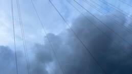 Photo of clouds with lines of wires stretched across the sky